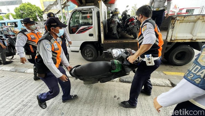 Dalam upaya penertiban trotoar, Suku Dinas Perhubungan (Sudinhub) Kota Administrasi Jakarta Pusat, menjaring puluhan kendaraan roda dua di trotoar, Jalan Pasar Senen, Jakarta Pusat, Kamis (24/02/2022). Puluhan kendaraan roda dua tersebut diangkut melanggar aturan karena parkir tidak pada tempatnya.