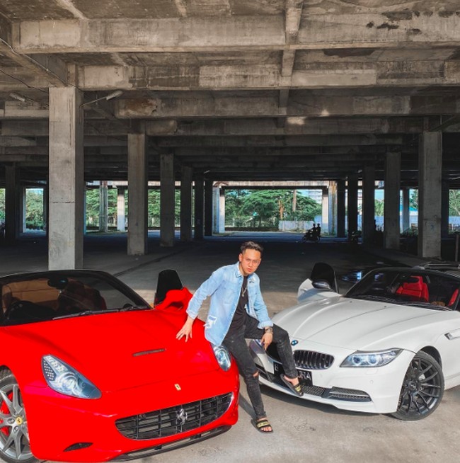 Di Instagramnya, Indra kerap memperlihatkan gaya hidup mewahnya. Seperti potretnya ini. Dia berpose di depan mobil mewah Ferrari dan BMW. Foto: dok. Instagram/@indrakenz