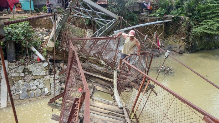 JEMBATAN RUSAK DI BOGOR Warga memaksakan diri melintasi jembatan rusak di Desa Sukarasa, Tanjung Sari, Kabupaten Bogor, Jawa Barat, Kamis (24/2/2022).Jembatan penghubung antara Desa Sukarasa dan Desa Cibadak tersebut rusak parah yang disebabkan luapan banjir Sungai Cisero beberapa waktu lalu dan mengakibatkan akses kedua desa tersebut terputus. ANTARA FOTO/Yulius Satria Wijaya/rwa.