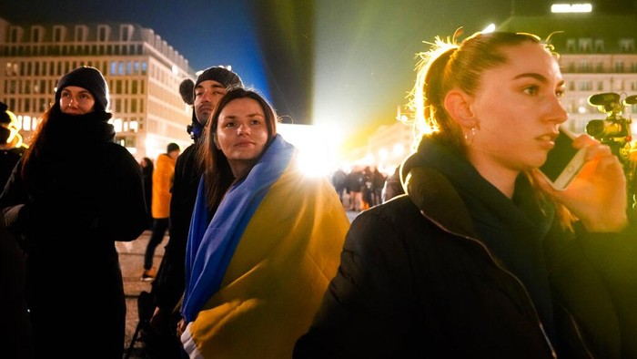 Makin Panas dengan Rusia, Jerman Beri Dukungan ke Ukraina A woman takes a photo of the Brandenburg Gate after it was illuminated in the colours of the Ukrainian flag to show solidarity with the country during the tensions with Russia in Berlin, Germany, Wednesday, Feb. 23, 2022. (AP Photo/Markus Schreiber)