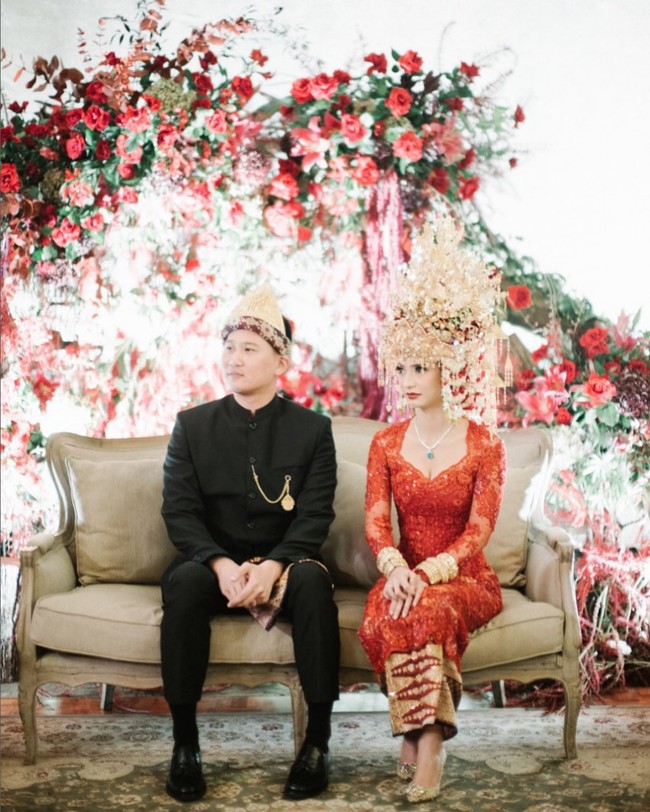 Nadia Saphira tampil cantik berkebaya merah dengan aksesori kepala khas pengantin Palembang saat menikahi Mikael Mirdad pada Desember 2019. Kebaya rancangan Resna Official itu dipadankan dengan songket berwarna senada. Foto: Instagram/@nadsap