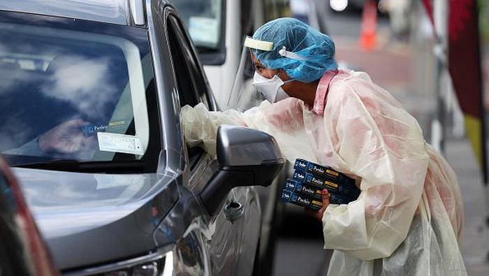 Nakes Selandia Baru Bagi-bagi Alat Antigen Gratis ke Warga AUCKLAND, NEW ZEALAND - FEBRUARY 24: Te Whanau o Waipareira essential heath workers hand out Rapid Antigen Tests to the waiting queue of cars in Henderson on February 24, 2022 in Auckland, New Zealand. Rapid antigen tests (RAT) are being given to people who present at community COVID-19 testing centres in Auckland from today, as demand for COVID-19 testing has increased due to the Omicron outbreak. People will still be able to get PCR tests at Auckland centres but will be able to test themselves at home with a RAT to get an indication of whether or not they have COVID-19. A positive RAT result does now not require any further testing. (Photo by Fiona Goodall/Getty Images)