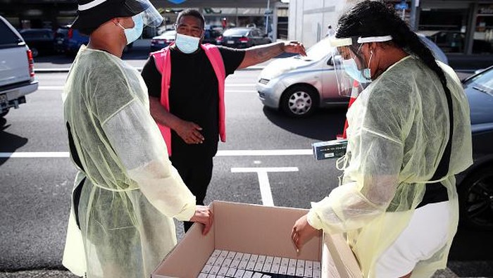 AUCKLAND, NEW ZEALAND - FEBRUARY 24: Te Whanau o Waipareira essential heath workers hand out Rapid Antigen Tests to the waiting queue of cars in Henderson on February 24, 2022 in Auckland, New Zealand. Rapid antigen tests (RAT) are being given to people who present at community COVID-19 testing centres in Auckland from today, as demand for COVID-19 testing has increased due to the Omicron outbreak. People will still be able to get PCR tests at Auckland centres but will be able to test themselves at home with a RAT to get an indication of whether or not they have COVID-19. A positive RAT result does now not require any further testing.  (Photo by Fiona Goodall/Getty Images)