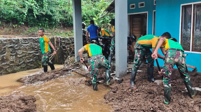 Prajurit TNI membantu warga membersihkan material longsor di Garut.