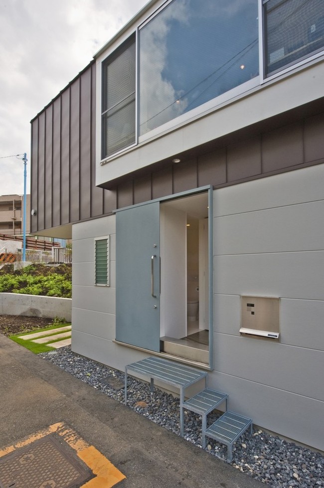 Rumah ramping ini ditinggali oleh sepasang suami istri yang memiliki seorang anak perempuan. Rumah ini terdiri dari dua lantai. Pintu utama rumah dibuat dengan model geser. Foto: Dok. ArchDaily.com/Fotografer Hiroshi Tanigawa