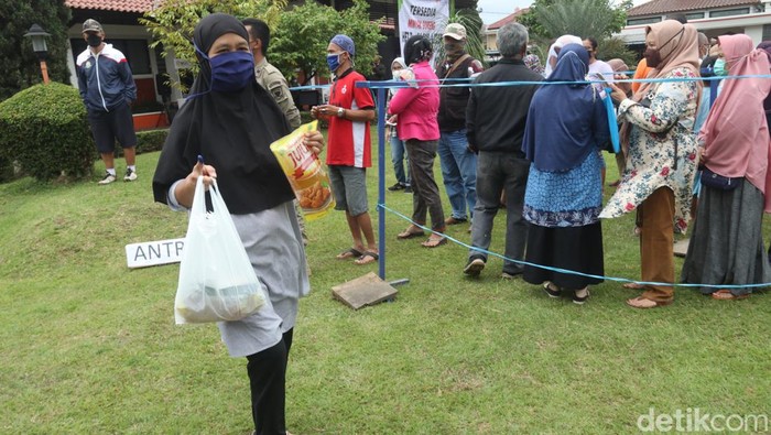 Warga antre minyak goreng saat operasi pasar Bulog Bandung.