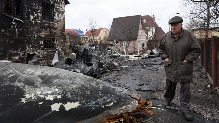 A woman walks around the wreckage of an unidentified aircraft that crashed into a house in a residential area, after Russia launched a massive military operation against Ukraine, in Kyiv, Ukraine February 25, 2022. REUTERS/Umit Bektas
