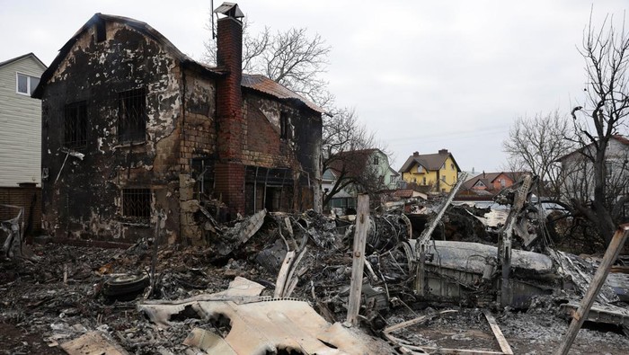 A woman walks around the wreckage of an unidentified aircraft that crashed into a house in a residential area, after Russia launched a massive military operation against Ukraine, in Kyiv, Ukraine February 25, 2022. REUTERS/Umit Bektas