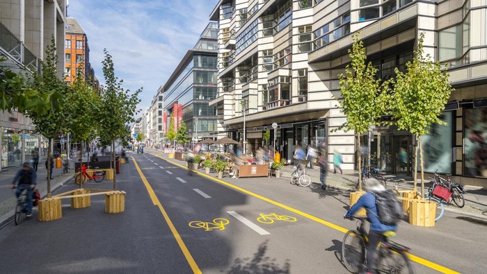 Pop-up bicycle lane in central Berlin with people biking, walking and relaxing. This is a trial concept for urban planning which improves the quality of life of people.