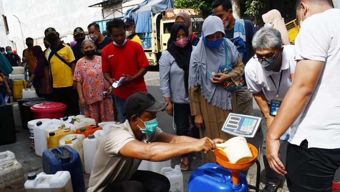 Pedagang Antre Minyak Goreng Curah di Madiun Warga mengangkut jeriken berisi minyak goreng curah yang dibelinya saat pendistribusian minyak goreng curah di Kota Madiun, Jawa Timur, Jumat (25/2/2022). Kementerian Perdagangan bekerja sama dengan PT Perusahaan Perdagangan Indonesia (Persero) mendistribusikan delapan ribu liter minyak goreng curah kepada para pedagang pasar dengan harga Rp10.500 per liter atau Rp11.700 per kilogram sehingga diharapkan bisa dijual kepada konsumen dengan harga Rp11.500 per liter atau Rp13.000 per kilogram guna menstabilkan harga dan mengatasi kelangkaan minyak goreng. ANTARA FOTO/Siswowidodo/nym.