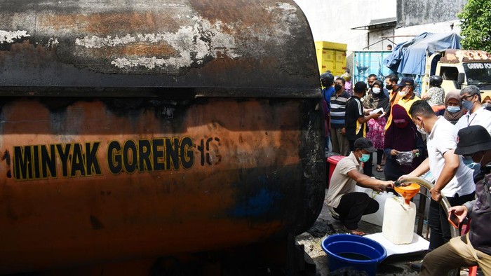 Pedagang Antre Minyak Goreng Curah di Madiun Warga mengangkut jeriken berisi minyak goreng curah yang dibelinya saat pendistribusian minyak goreng curah di Kota Madiun, Jawa Timur, Jumat (25/2/2022). Kementerian Perdagangan bekerja sama dengan PT Perusahaan Perdagangan Indonesia (Persero) mendistribusikan delapan ribu liter minyak goreng curah kepada para pedagang pasar dengan harga Rp10.500 per liter atau Rp11.700 per kilogram sehingga diharapkan bisa dijual kepada konsumen dengan harga Rp11.500 per liter atau Rp13.000 per kilogram guna menstabilkan harga dan mengatasi kelangkaan minyak goreng. ANTARA FOTO/Siswowidodo/nym.