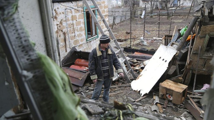 A local citizen stands between debris of his house following Ukrainian shelling in the territory controlled by pro-Russian militants, eastern Ukraine, Thursday, Feb. 24, 2022. Russian troops have launched a three-pronged assault on Ukraine that opened with air and missile strikes on Ukrainian military facilities and included ground troops invading from Crimea. (AP Photo/Alexei Alexandrov)