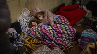 Seorang ibu dan anaknya berbaring di stasiun kereta bawah tanah Kyiv, menggunakannya sebagai tempat perlindungan bom di Kyiv, Ukraina.