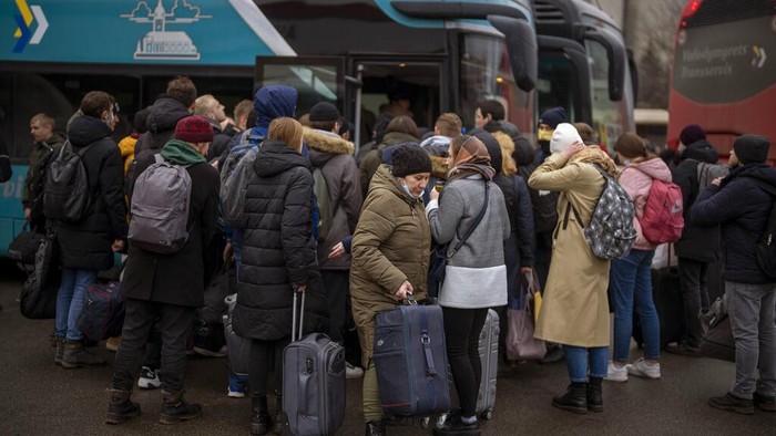 People walk in a subway to get a train as they leave the city of Kyiv, Ukraine, Thursday, Feb. 24, 2022. Russian President Vladimir Putin on Thursday announced a military operation in Ukraine and warned other countries that any attempt to interfere with the Russian action would lead to 