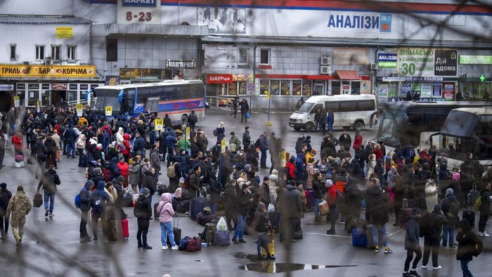 People walk in a subway to get a train as they leave the city of Kyiv, Ukraine, Thursday, Feb. 24, 2022. Russian President Vladimir Putin on Thursday announced a military operation in Ukraine and warned other countries that any attempt to interfere with the Russian action would lead to 