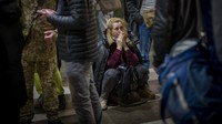 Seorang wanita bereaksi ketika dia menunggu kereta yang mencoba meninggalkan Kyiv, Ukraina.
