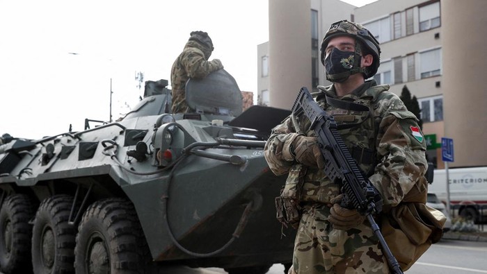 Rusia Serang Ukraina, Tentara Hongaria Siaga Hungarian army members stand guard as people flee from Ukraine to Hungary, after Russia launched a massive military operation against Ukraine, in Vasarosnameny, Hungary, February 25, 2022. REUTERS/Bernadett Szabo
