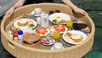 Tak kalah kekinian, Susana Rahardjo juga tak mau ketinggalan menikmati floating breakfast. Ada menu nasi goreng hingga buah-buahan di sana. Foto: Instagram @susana.rahadrjo