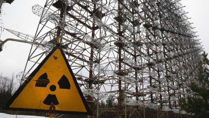 FILE - A Soviet-era top secret object Duga, an over-the-horizon radar system once used as part of the Soviet missile defense early-warning radar network, seen behind a radioactivity sign in Chernobyl, Ukraine, on Nov. 22, 2018. Among the most worrying developments on an already shocking day, as Russia invaded Ukraine on Thursday, was warfare at the Chernobyl nuclear plant, where radioactivity is still leaking from historys worst nuclear disaster 36 years ago. (AP Photo/Efrem Lukatsky, File)