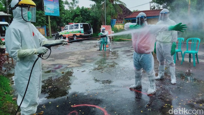 Tim pemakaman COVID-19 Kabupaten Klaten disemprot disinfektan usai bertugas, tahun 2021.