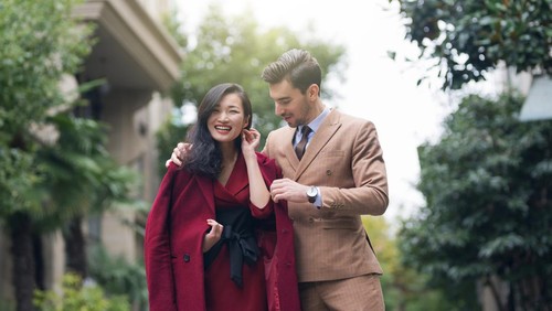 Handsome young couple,walking down the street in formal elegant clothes,showing each other how much they care for each other in a subtle way.