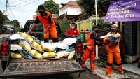Sejumlah warga memberikan bantuan logistik kepada warga yang menjalani isolasi mandiri di kawasan RW 10, Pondok Bambu, Kecamatan Duren Sawit, Jakarta Timur, Sabtu (26/2). 