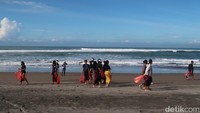 Ratusan orang berpakaian khas Bali saat berkumpul di depan tulisan pantai Parangkusumo, Bantul. 