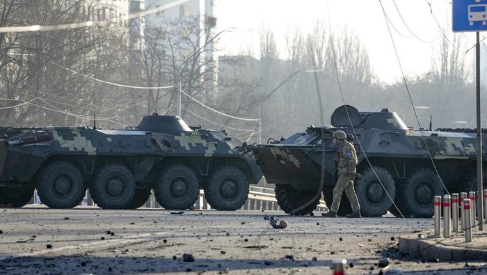 A soldier walks along Ukrainian armored vehicles blocking a street in Kyiv, Ukraine, Saturday, Feb. 26, 2022. Russian troops stormed toward Ukraines capital Saturday, and street fighting broke out as city officials urged residents to take shelter. (AP Photo/Efrem Lukatsky)