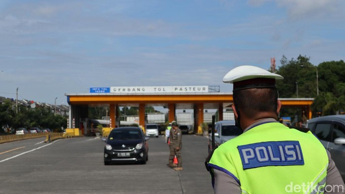 Petugas menyisir kendaraan di gerbang tol, penerapan aturan ganjil genap di Bandung.