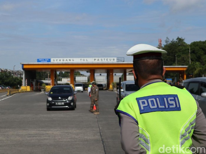 Petugas menyisir kendaraan di gerbang tol, penerapan aturan ganjil genap di Bandung.