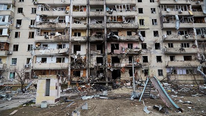 KYIV, UKRAINE - FEBRUARY 25: A boy plays on a swing in front of a damaged residential block hit by an early morning missile strike on February 25, 2022 in Kyiv, Ukraine. Yesterday, Russia began a large-scale attack on Ukraine, with Russian troops invading the country from the north, east and south, accompanied by air strikes and shelling. The Ukrainian president said that at least 137 Ukrainian soldiers were killed by the end of the first day. (Photo by Chris McGrath/Getty Images)