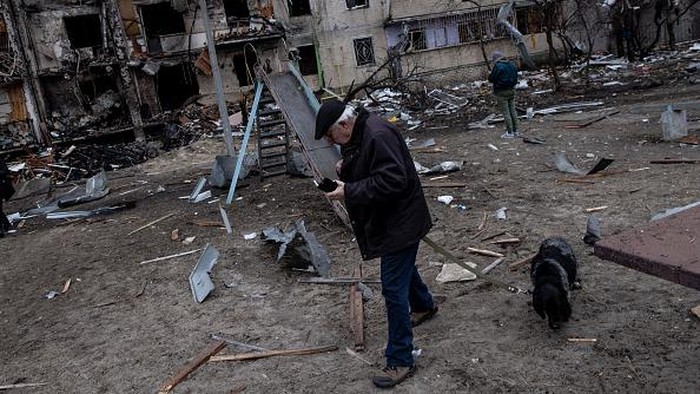 KYIV, UKRAINE - FEBRUARY 25: A boy plays on a swing in front of a damaged residential block hit by an early morning missile strike on February 25, 2022 in Kyiv, Ukraine. Yesterday, Russia began a large-scale attack on Ukraine, with Russian troops invading the country from the north, east and south, accompanied by air strikes and shelling. The Ukrainian president said that at least 137 Ukrainian soldiers were killed by the end of the first day. (Photo by Chris McGrath/Getty Images)