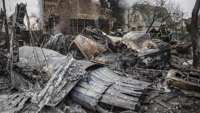 A Ukrainian firefighter walks between at fragments of a downed aircraft seen in in Kyiv, Ukraine, Friday, Feb. 25, 2022. It was unclear what aicraft crashed and what brought it down amid the Russian invasion in Ukraine Russia is pressing its invasion of Ukraine to the outskirts of the capital after unleashing airstrikes on cities and military bases and sending in troops and tanks from three sides. (AP Photo/Oleksandr Ratushniak)
