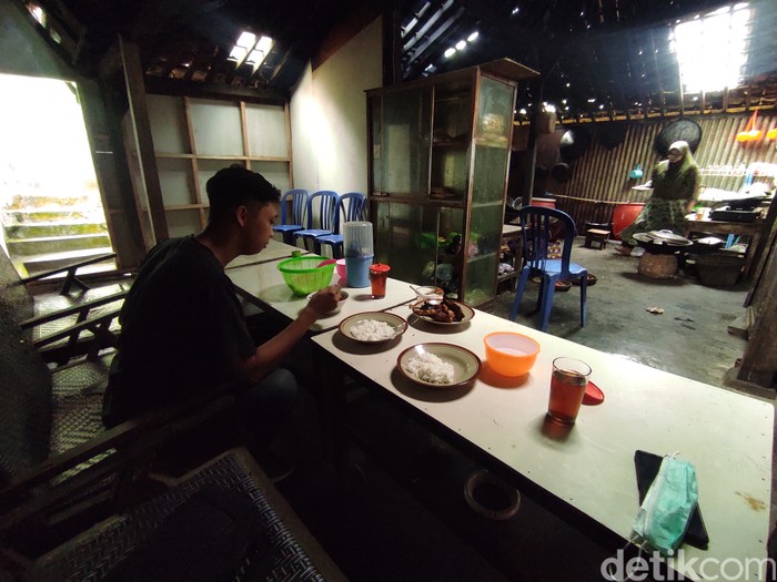 Salah satu pelanggan saat menikmati ayam panggang di dapur Warung Makan Bu Bari, Sabtu (26/2/2022).