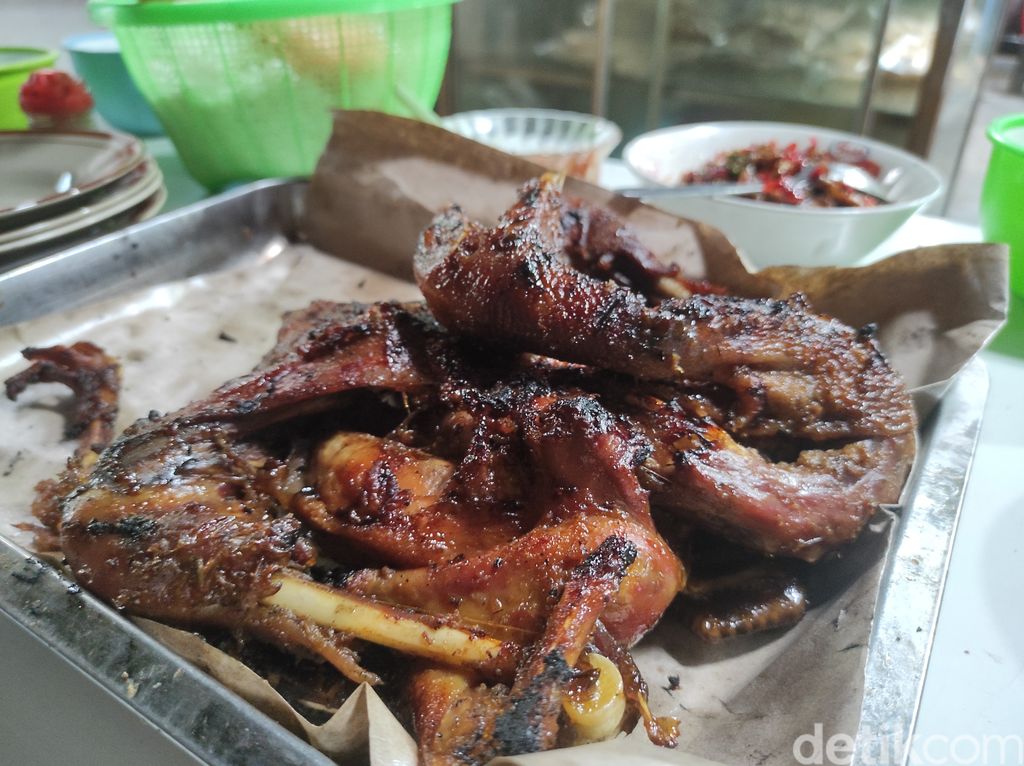 Salah satu pelanggan saat menikmati ayam panggang di dapur Warung Makan Bu Bari, Sabtu (26/2/2022).