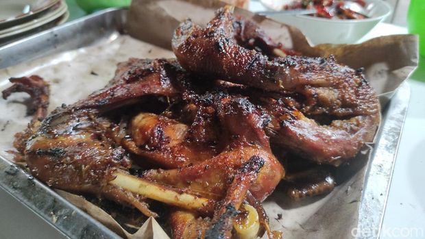 Salah satu pelanggan saat menikmati ayam panggang di dapur Warung Makan Bu Bari, Sabtu (26/2/2022).