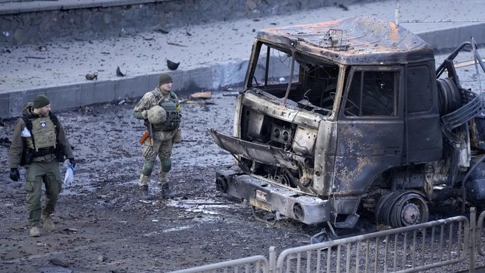 Ukrainian troops inspect the site following a Russian airstrike in Kyiv, Ukraine, Saturday, Feb. 26, 2022. (AP Photo/Vadim Ghirda)