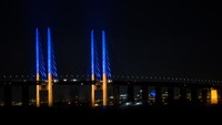 Pemandangan menunjukkan tiang di Jembatan Oresund, antara Denmark dan Swedia, menyala kuning dan biru untuk mendukung Ukraina, seperti yang terlihat dari Kopenhagen, Denmark. via REUTERS/RITZAU SCANPIX