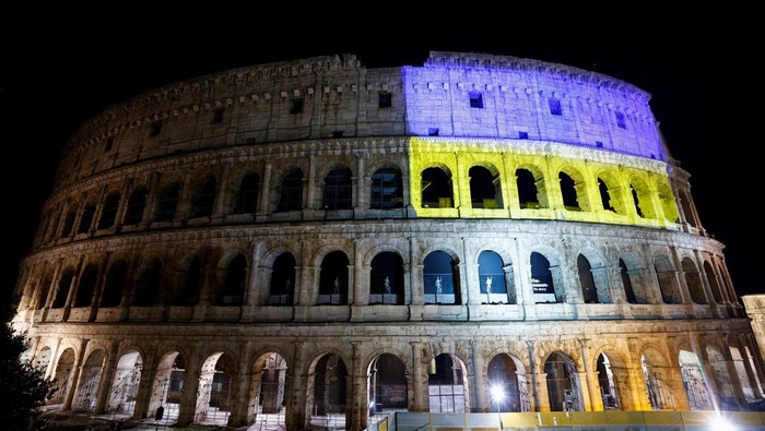 Bendera Ukraina Terangi Bangunan Ikonik Sejumlah Negara Rome's ancient Colosseum is illuminated in the colours of the Ukrainian flag, in Rome, Italy, February 24, 2022. REUTERS/Guglielmo Mangiapane