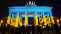 Gerbang Brandenburg terlihat menyala dengan warna bendera Ukraina selama protes anti-perang, setelah Presiden Rusia Vladimir Putin mengizinkan operasi militer di Ukraina timur, di Berlin, Jerman. REUTERS/CHRISTIAN MANG