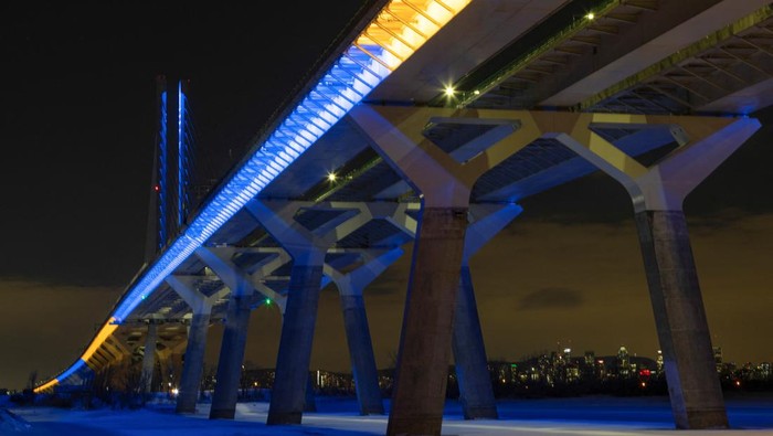 Bendera Ukraina Terangi Bangunan Ikonik Sejumlah Negara The Samuel de Champlain Bridge is lit in yellow and blue to show Canada's support for the Ukranian people in Montreal, Canada February 26, 2022. REUTERS/Christinne Muschi