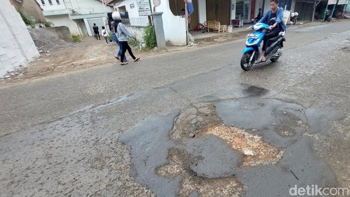 Ruas jalan di Jalan  Raya Cikancung-Cicalengka, Kabupaten Bandung, alami kerusakan yang cukup parah. Tak jarang kendaraan yang melintas pun jadi ikut rusak, Minggu, 27/2/2022.