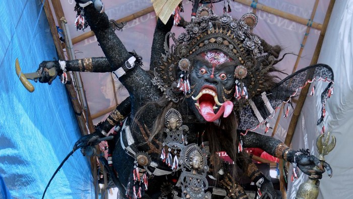 Warga berfoto di dekat Ogoh-ogoh berjudul Gerubug karya kelompok pemuda ST. Tunas Muda di Sidakarya, Denpasar, Bali, Minggu (27/2/2022). Ogoh-ogoh yang akan diarak pada malam pengrupukan atau sehari sebelum Hari Raya Nyepi yang terbuat dari bahan-bahan ramah lingkungan serta masker menggambarkan kondisi kehidupan sosial, budaya dan ekonomi masyarakat selama masa pandemi COVID-19. ANTARA FOTO/Fikri Yusuf/aww.