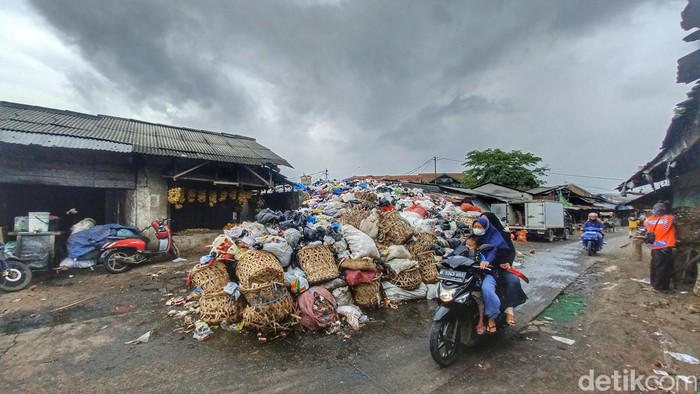 Pemotor melintasi tumpukan sampah di Pasar Majalaya, Kabupaten Bandung.