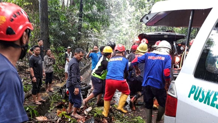 Petugas evakuasi jenazah pemotor yang tewas tertimpa pohon tumbang.