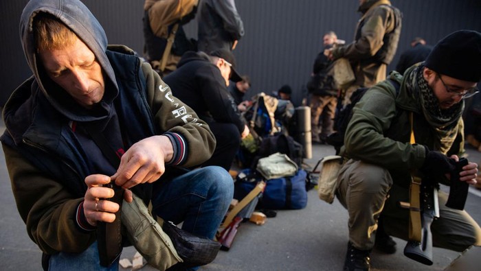 Members of the Territorial Defence Forces of Ukraine load ammunition after receiving weapons to defend the city of Kyiv, Ukraine February 25, 2022. Mikhail Palinchak/Pool via REUTERS