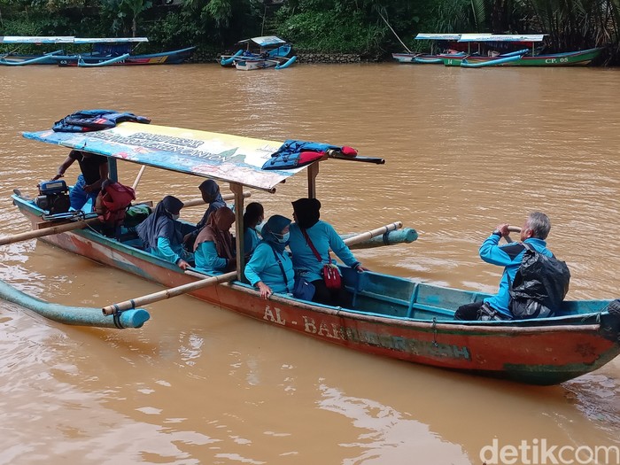 Wisatawan menggunakan perahu di Sungai Cijulang.