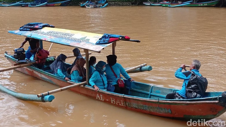 Wisatawan menggunakan perahu di Sungai Cijulang.
