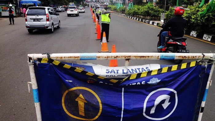 Antisipasi Macet, Gage Diberlakukan di Jalur Puncak Petugas Sat Lantas Polres Bogor mengarahkan kendaraan wisatawan saat penyekatan kendaraan ganjil genap di jalur wisata Puncak, Gadog, Kabupaten Bogor, Jawa Barat, Senin (28/2/2022). Penyekatan dan pemberlakuan ganjil genap tersebut sebagai upaya mencegah kepadatan kendaraan wisatawan di jalur wisata Puncak saat libur Isra Miraj Nabi Muhammad SAW 1443 h. ANTARA FOTO/Yulius Satria Wijaya/hp.