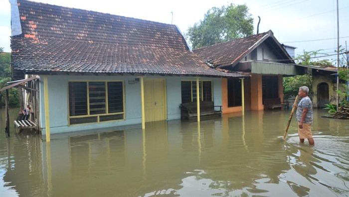 Pengendara sepeda motor melintas di jalan yang tergenang air di Desa Tanjungkarang, Jati, Kudus, Jawa Tengah, Senin (28/2/2022). Akibat curah hujan yang tinggi serta drainase yang buruk menyebabkan puluhan rumah serta beberapa jalan utama di desa itu terendam banjir. ANTARA FOTO/Yusuf Nugroho/tom.